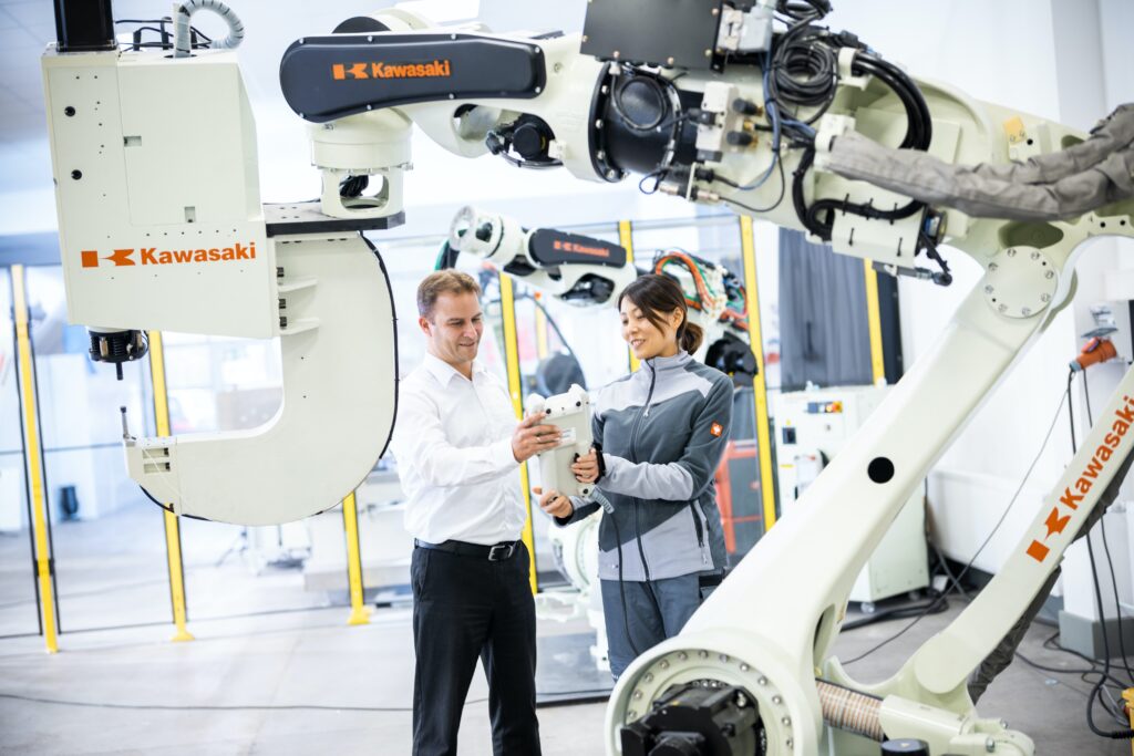 Asian woman and white man looking at a piece of technology while in a manufacturing facility